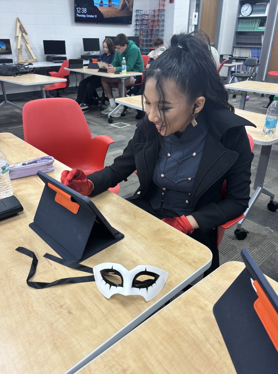 Dressed up for Halloween, senior Bella Tran works on her engineering work. Tran’s outfit was costume made by a family member.  “My mom has a cousin in Vietnam who makes Vietnamese dresses, and we asked her to make the vest and jacket for me,” Tran said, “And I just chose the character because he's from a game that my friends and I really enjoy.”